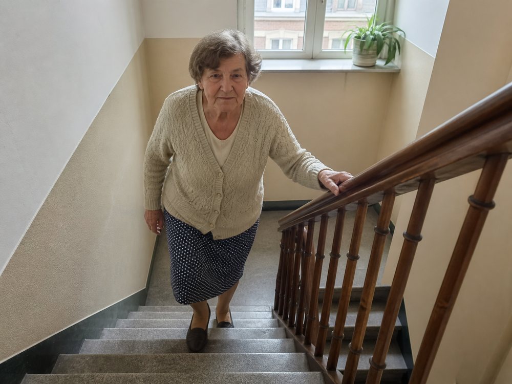 Photo illustrative d’une femme âgée montant un escalier